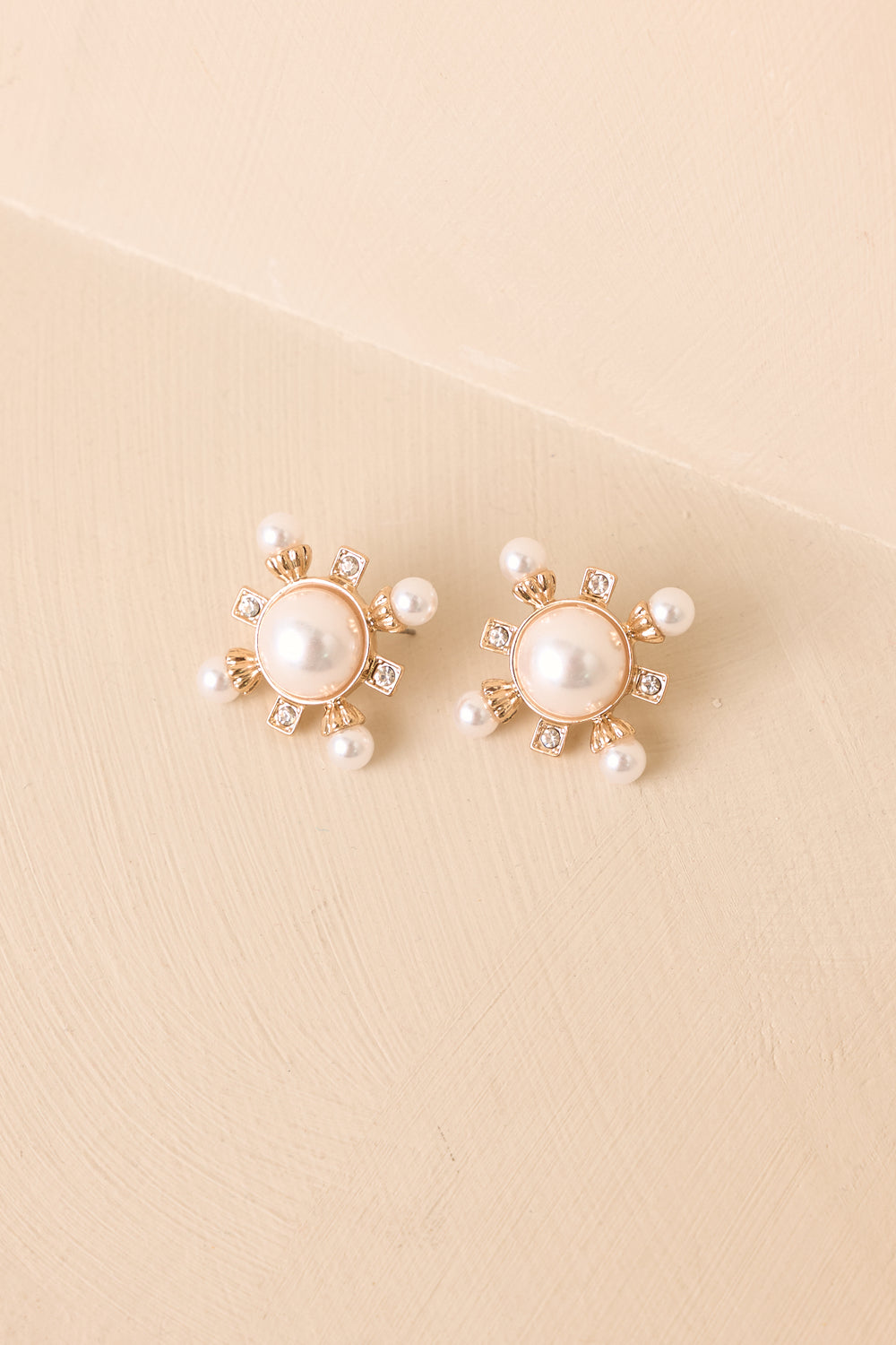 Faux-Pearl-And-Crystal-Stud-Earrings-On-Beige-Background-7d69-4847-af74-23da7975eeb0