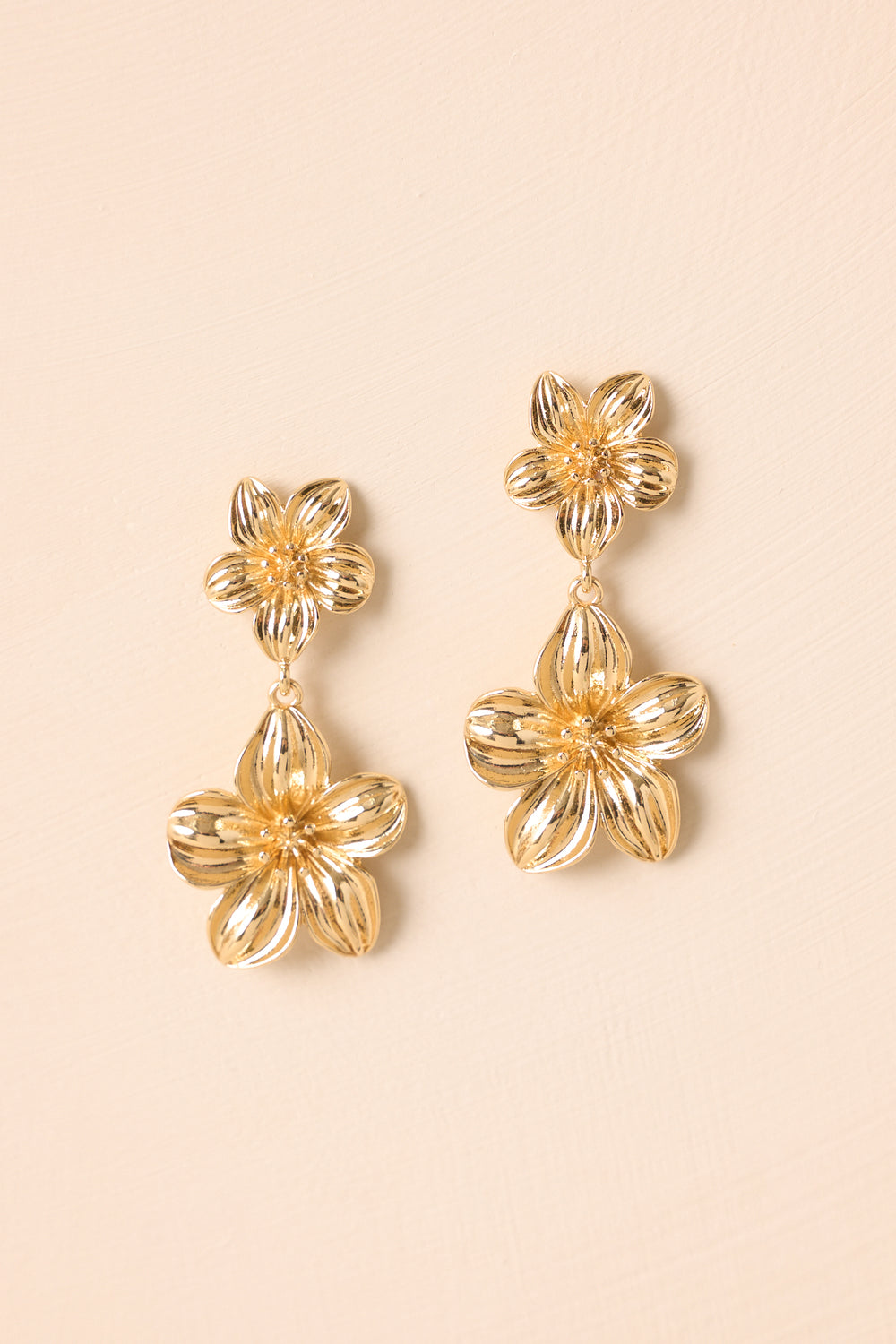 Gold-Flower-Earrings-On-Beige-Background