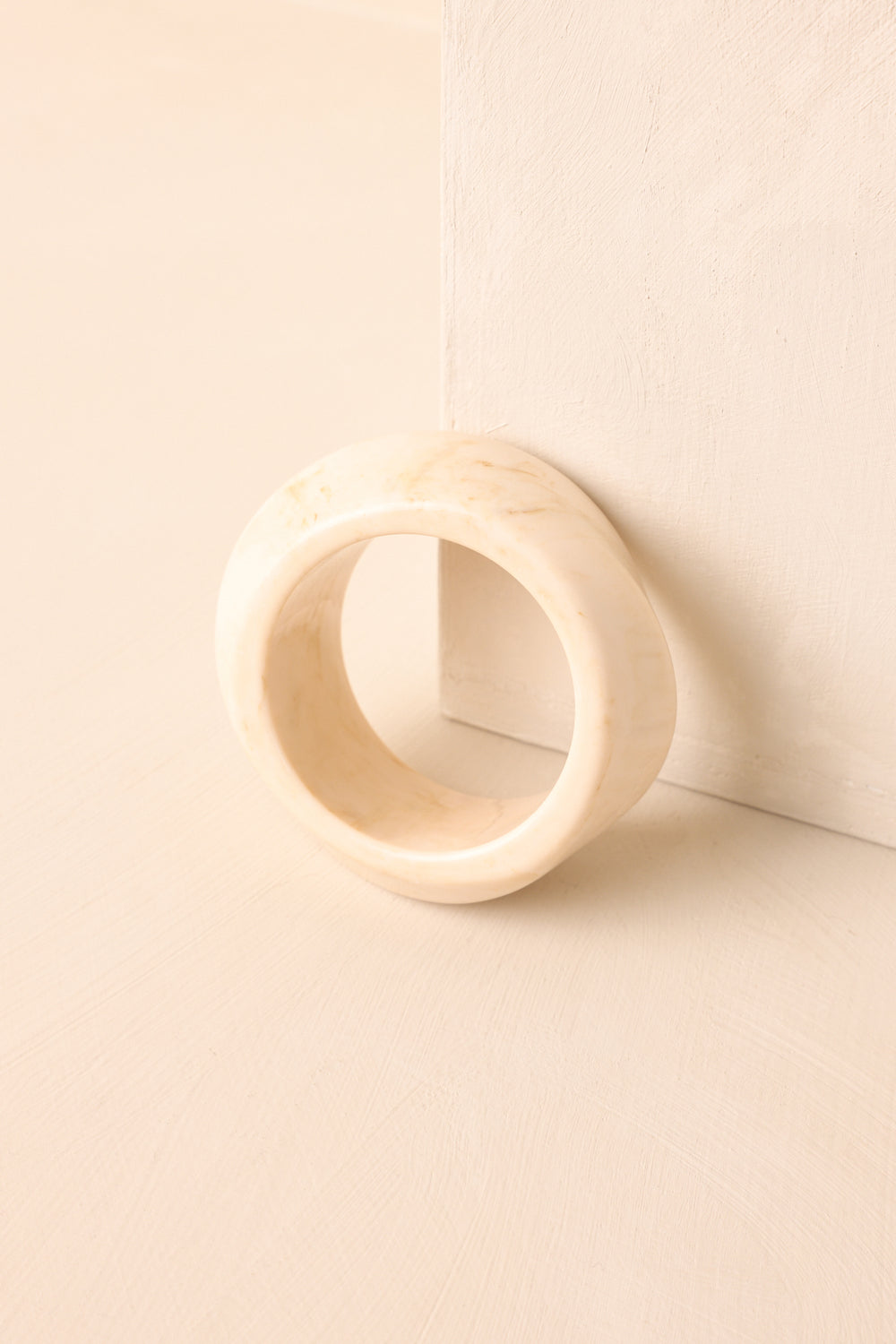 ivory-marble-acrylic-wide-chunky-bangle-bracelet-backdrop-tilted-on-wall